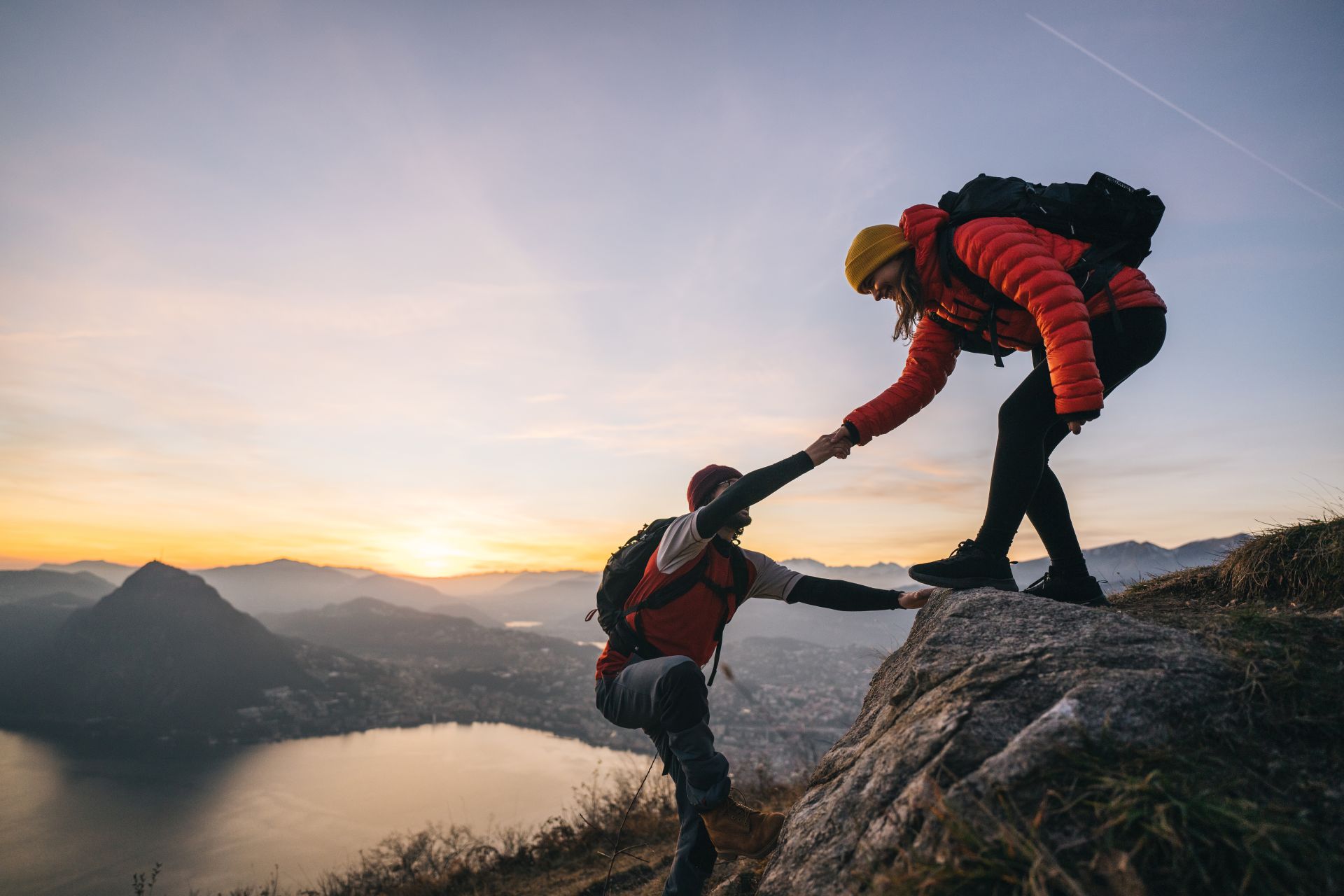 Foto: Zwei Bergsteigende, die sich gegenseitig helfen.
